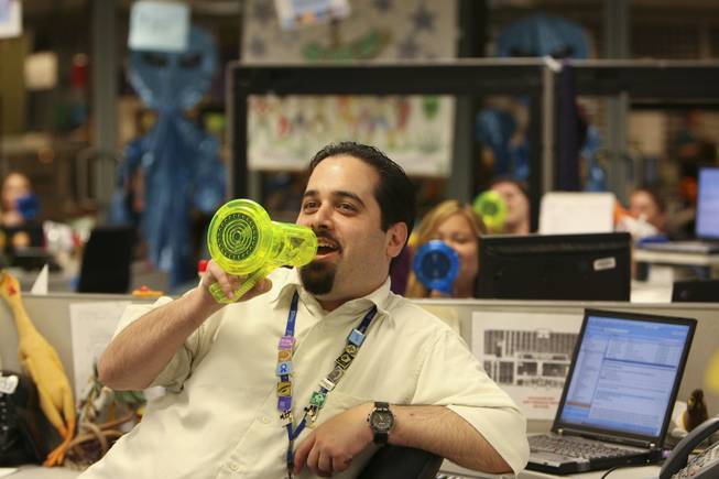 Speaking into "alien"-sounding megaphones, Scott Klein and his co-workers welcome a tour into the Customer Loyalty Team Department -- known as Area 52 -- Thursday at the corporate offices of Zappos.com in Henderson.
