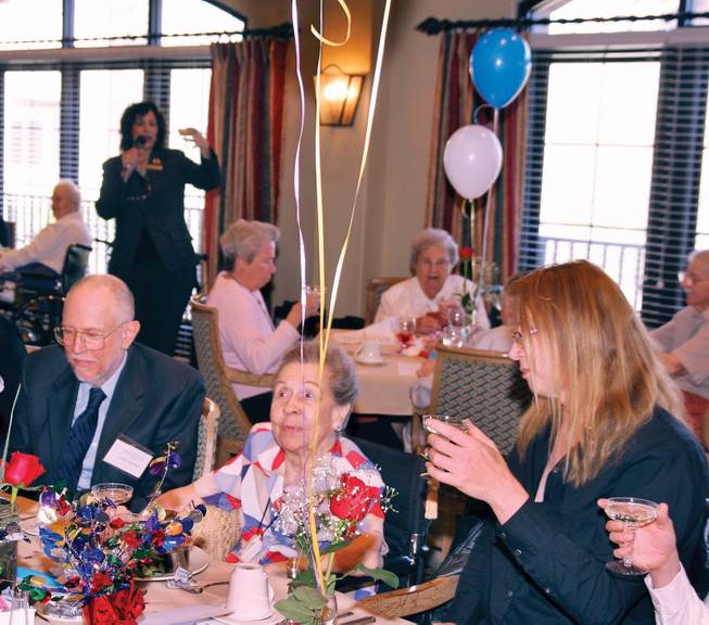 Activity Coordinator Maria Truelock, background left, proposes a toast to 100-year-old Lola Lovell, center,  during a birthday celebration at Las Ventanas. Lola is joined by her son Bruce Lovell, left, and her granddaughter Marcie Lovell right. 