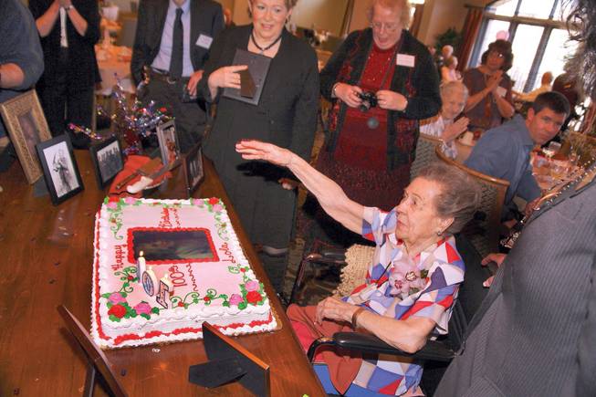 Centenarian Lola Lovell, center, waves to a friend during her 100th birthday celebration at Las Ventanas.