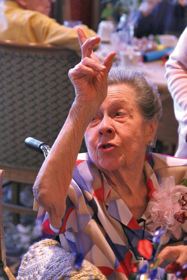 Lola Lovell raises her hand to answer to the call for "Miss Lola" during her 100th birthday celebration at Las Ventanas.