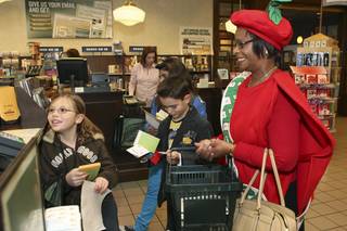 At the conclusion of their Barnes & Noble shopping spree Wednesday, from left, Faith Teagarden, JamiLynn Merolle, Keegan Tharp and Principal Deborah Harbin pay for their books with the $25 gift cards they received as a reward for winning the Elise Wolff Elementary School APPLE Core reading program.
