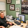 Faith Lutheran head football coach Jake Kothe shows off a photograph of Kothe's son Elijah, 10, and Arizona Cardinals' quarterback Kurt Warner on the computer in his office. Kothe played with Warner at Northern Iowa.
