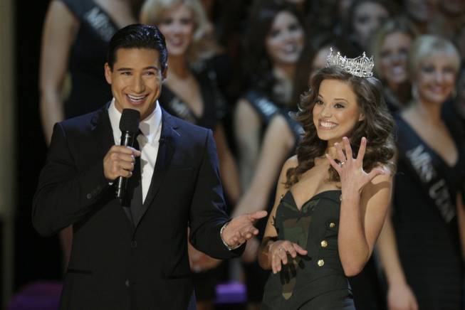 Katie Stam, Miss America 2009, shows off her engagement ring as host Mario Lopez looks on during the 2010 Miss America Pageant at Planet Hollywood.