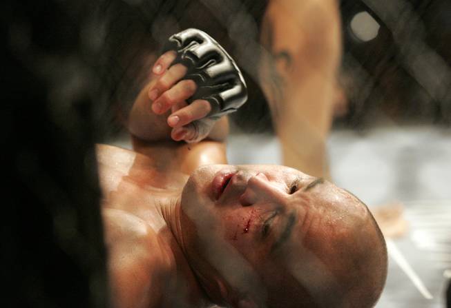 B.J. Penn lays on the mat after the third round ...