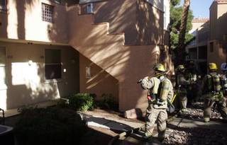 Firefighters gather outside the Cha Cha Cha Apartments, 640 E. Horizon Drive, after extinguishing a small patio fire Monday. The fire was quickly controlled without any damage to other units.    