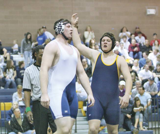 The referee raises the right hand of Boulder City High's Kyle Erickson, right, in victory after he beat Foothill's Jake Broyles during a meet at Boulder City High.