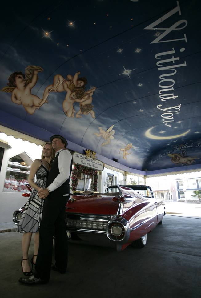 Kurt Langer from New Zealand and Karen Kerr pose for photographs just after they were married at the drive thru window at the Little White Wedding Chapel.