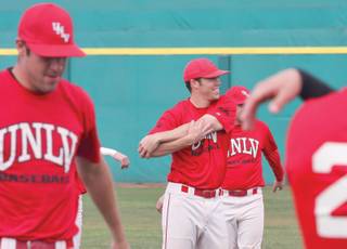 UNLV pitcher Stephen Singer, center, smiles during warm-ups at the Rebels' baseball practice.
