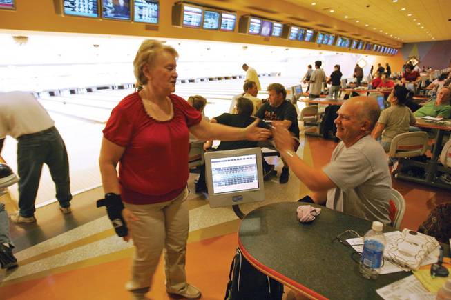 Linda Sterner high fives with her husband Wes while bowling at Texas Station.