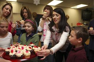 Second-grade teacher Lisa Aquino selects a Valentine's Day cupcake delivered as a gift by Freed's Bakery Friday morning at Glen Taylor Elementary School. Teachers' children were present for the celebration.  From left: Austin Almeido, Lisa Aquino, Shelly Soule, Arabella Carter, Renee Colvin, Marie Almeido and Alexis Almedio.