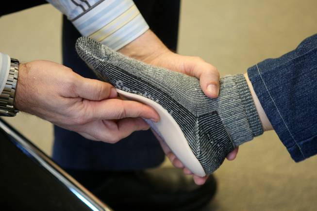 Perfect fit: DeWitt Paul checks the fit of a custom orthotic insole after making the insole using the Varifit Orthodic Fabrication System in the Foot Solutions store in Henderson. 