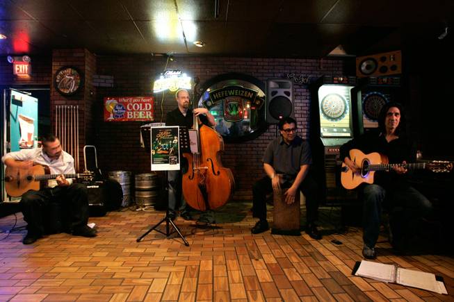 The gypsy jazz group Hot Club of Las Vegas rehearses at Money Plays, a bar on West Flamingo Road in Las Vegas, on Wednesday, Feb. 4, 2009. From left is Marlow Valentin on guitar, Chris Davis on bass, Gabriel Santana Falcon playing the cajon, a percussion instrument, and Mundo Juillerat, the leader of the band on guitar.