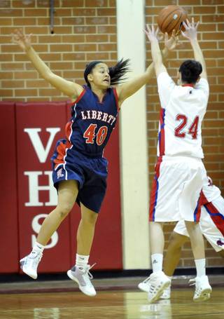 Liberty High School's Jade Washington, left, goes for the block against Valley High School's Vanissa Corona during their match up at Valley High School on Thursday.