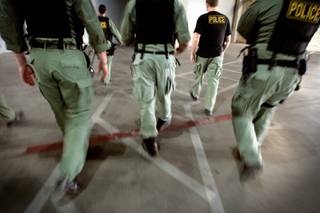 Members of Metro Police's vice unit walk from the parking garage to the service elevators of a Las Vegas Boulevard condo tower in 2009 to search the condominium of a suspected pimp. 