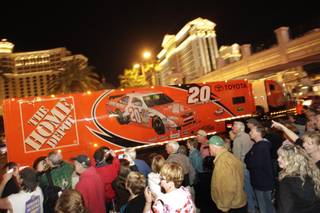 Joey Logano's car hauler passes by fans during a parade of NASCAR haulers on the Las Vegas Strip on Thursday, Feb. 25, 2010.