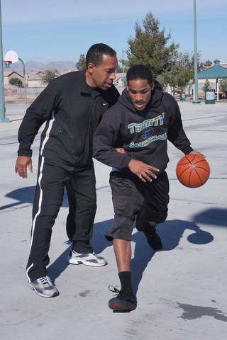Budweiser Hawkins III, right, a junior guard for Trinity Christian and his father Budweiser Hawkins II play basketball together at Desert Bloom Park. 
