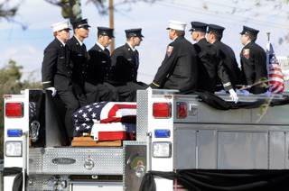 Henderson Fire captain Tim Vite (far left), and other members of 20-year veteran Jeff Mann's Station 82 shift escort Mann's flag-draped casket as it rides in the back of a Paramedic Engine during a motor processional from Palm Mortuary on Boulder Highway to a Latter-day Saints chapel on Arrowhead Trail on Wednesday. Mann lost a battle with cancer on Feb. 27.