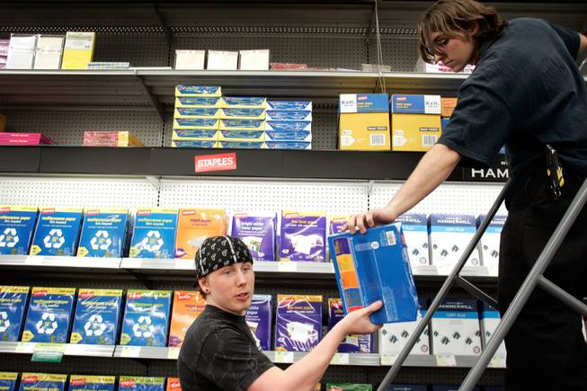 Office supply associates Doug Kaedy, left, and Guy Townsend stock the shelves with printer paper at the Henderson Staples on March 2.