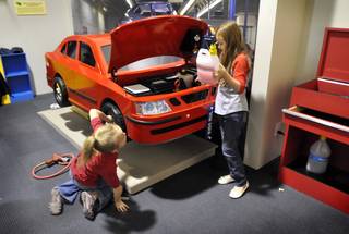 Brianna Reed, left and Abigail Johnson, tend to the vehicle inside the car exhibit the newly opened Green Village display at the Lied Discovery Childrens Museum on Tuesday, March 10, 2009. The 3,500 square-foot mini-city has an environmentally friendly focus that includes exhibits with lessons in everyday living and environmental sustainability.