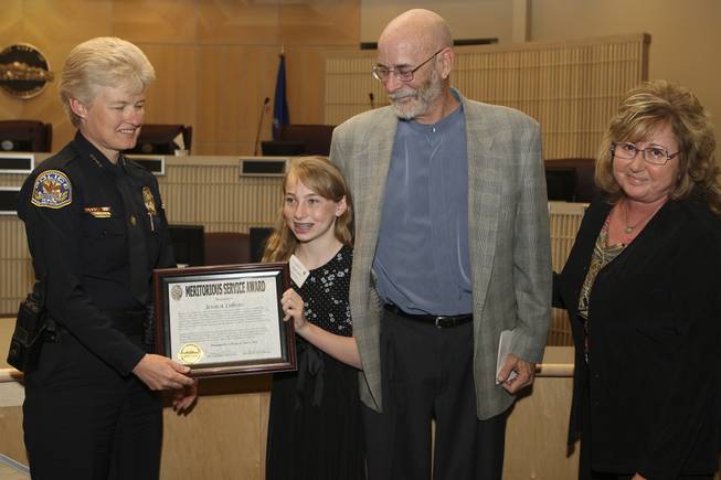 Honored for her quick and calm response, Jessica Lukens, 11, receives a Meritorious Service Award, for helping to save her father's life while having a heart attack, from Henderson Police Chief Jutta Chambers Wednesday during the 6th Annual Commendation Award Ceremony.  Standing next to her is her father and mother, John and Donna Lukens.