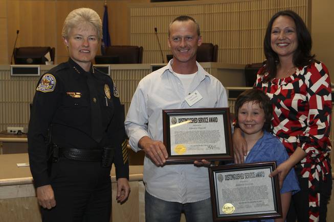 Henderson Police Chief Jutta Chambers honors Edward Ducsak and Jennifer Larivee with her son, Bear, with Distinguished Service Awards, for their heroic efforts in apprehending a suspect of a robbery who sought refuge in their home, during the 6th Annual Commendation Ceremony Wednesday.