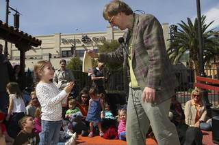 Four-year-old Isabella Whittenberg helps Magician Mac King with a storybook trick during storytime Wednesday in Town Square plaza in celebration of National Reading Month.