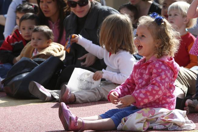 Three-year-old Caroline Carender giggles listening to Magician Mac King read "Sideways Stories From Wayside School" by Louis Sachar during storytime Wednesday in Town Square plaza in celebration of National Reading Month.