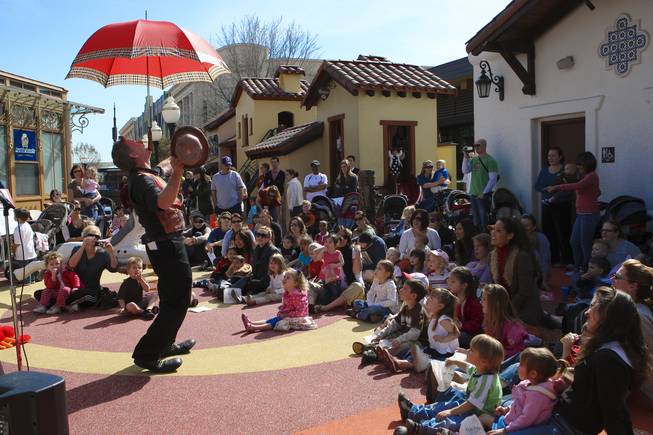 Host Ray Wold, of the Amazing Clowns, performs an umbrella trick during storytime Wednesday in Town Square plaza in celebration of National Reading Month.
