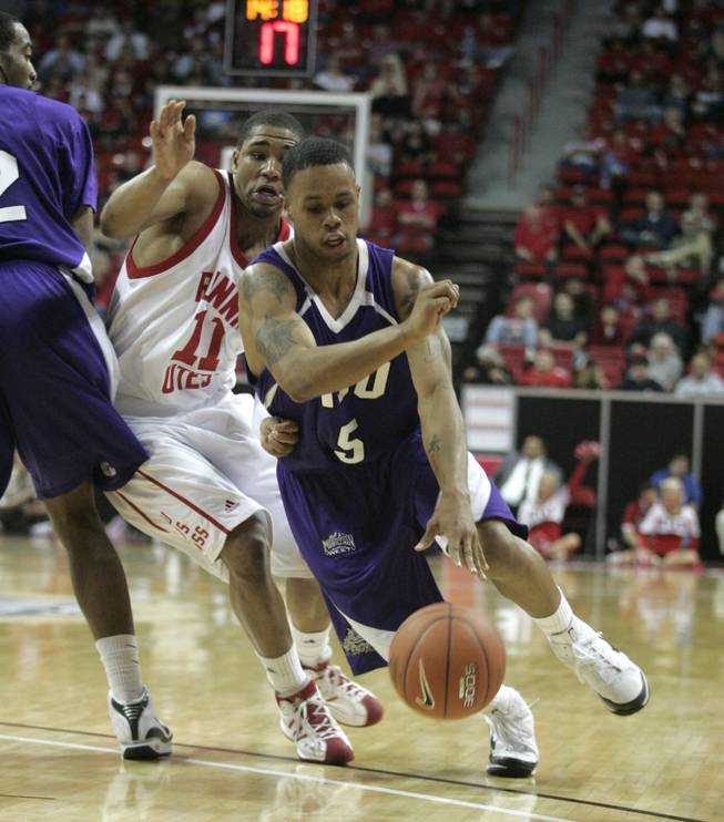 Utah guard Lawrence Borha is caught in a pick as TCU guard Ronnie Moss drives past him at the Mountain West Conference Basketball Championships Thursday, March 12, 2009.  Utah won the game 61-58 on a last-second three point shot.