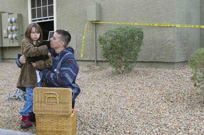 Jonathan Arberg consoles his eight-year-old daughter, Brittany, and her cat, Boots, after their apartment was completely destroyed in a fire Thursday morning at the Crossing Apartments, 2312 North Green Valley Parkway in Henderson.