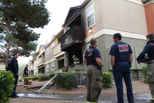 Henderson Firefighters of Engine 94 stand outside apartment 1111 working with Investigator Don Spellman after a fire Thursday morning at the Crossing Apartments, 2312 North Green Valley Parkway in Henderson. 