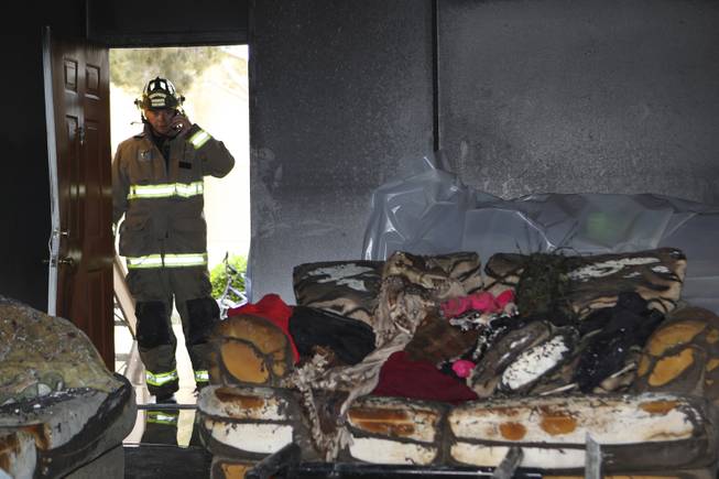 Henderson Fire Investigator Don Spellman examines the living room that was destroyed in Apartment 1111 Thursday morning at the Crossing Apartments, 2312 North Green Valley Parkway in Henderson. 