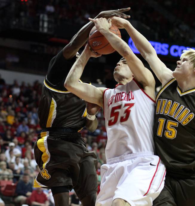 Daniel Faris gets blocked by two Cowboy defenders as New Mexico takes on Wyoming on Thursday in the Mountain West Conference tournament at the Thomas & Mack Center. 