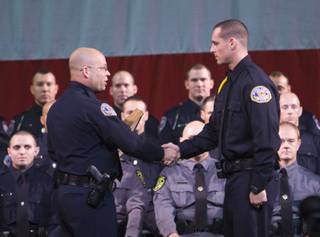 Henderson Police Cadet Ronald Feola, right, is awarded the valedictorian by TAC Officer Dave Adams during the graduation ceremony of the Southern Desert Regional Police Academy Thursday.