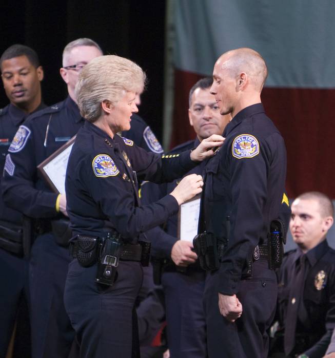 Henderson Police Chief Jutta Chambers pins Karl Lippisch's badge on his uniform during the graduation ceremony of the Southern Desert Regional Police Academy Thursday.