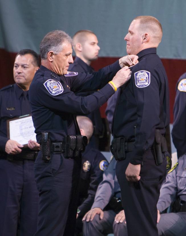 North Las Vegas Police Chief Joseph Forti pins Alan Brushs badge on his uniform during the graduation ceremony of the Southern Desert Regional Police Academy Thursday.