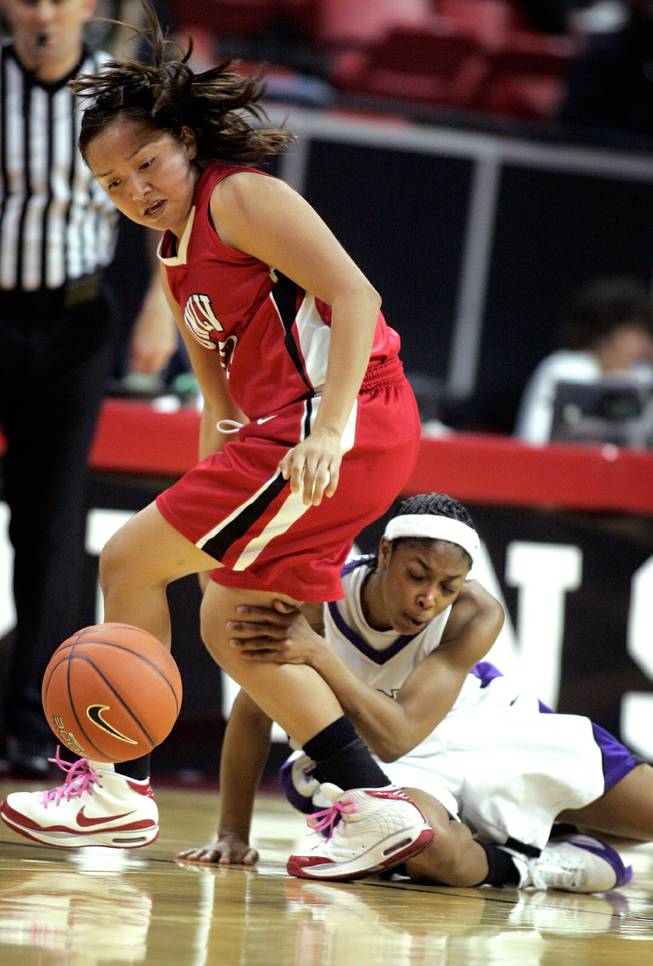 Allison Holiday, left, of UNLV and TK LaFleur of Texas Christian University scramble for a loose ball during the quarterfinals of the Mountain West Championship on Wednesday at the Thomas & Mack Center.