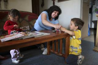 Although worried about the family's finances, Rachel Lucero, 39, is enjoying her time with children, Isabella, 2, and Gabriel, 4, right, while continuing to look for a job after being laid off from Progressive Gaming International in September.