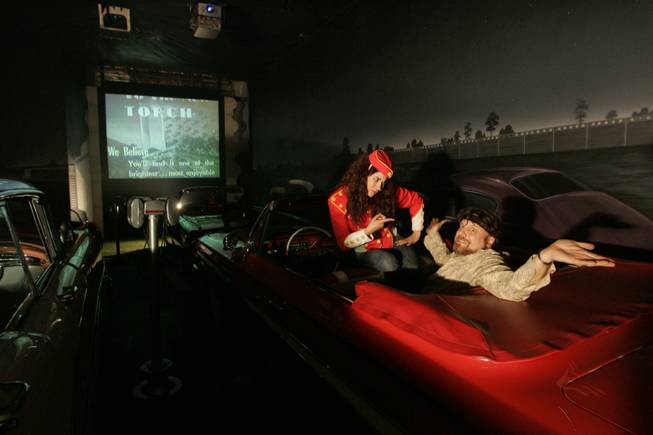 The Amazing Jonathan and assistant Erica Vanlee sit in one of the magician's cars at his indoor drive-in theater, which has been made to look like the Detroit drive-in where he worked in the '70s and '80s.