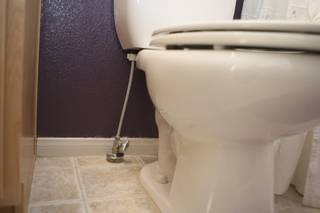 The water line to a toilet at Mike Turnbull's home comes through the vinyl floor instead of the wall as originally installed. Running the lines through the floor causes less damage when replacing them.