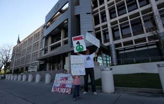 Corey Dragge and his two daughters, Lilly (left) and Keria, protest in support of ending the Darfur conflict in front of the Foley Federal Building Friday afternoon.  Dragge hopes to raise awareness about the issues surrounding the Darfur region of Africa.

