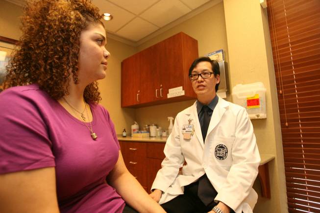 Dr. James Lau, chief of bariatric surgery at University Medical Center, speaks with Jennifer Cox, a teen who overcame obesity.