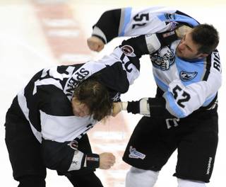 Wranglers left winger Tim Spencer, left, turns away from a right hand thrown by Aces winger Robin Richards as the two dropped gloves four seconds into the game at the Orleans Arena on Saturday night.