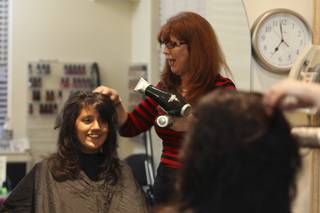Destinee, 13, visits with Cookie Seminario, right, while having her new haircut styled Monday during 
