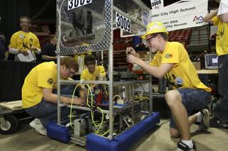 Boulder City's High Scalers team members, from left, Sean Hickey, 16, Nathan Richard, 15, and Austin Tobler, 15, make final adjustments on their robot in preparation for the practice round Thursday at the FIRST Robotics competition at the Thomas & Mack Center.