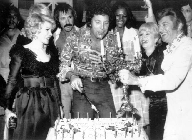 British singer Tom Jones, centre, blows out candles at a surprise birthday party at Caesar's Palace, Las Vegas, June 6, 1974. Guests include, from left to right, Joan Rivers, Sonny Bono, Jones, Debbie Reynolds, and Liberace. 