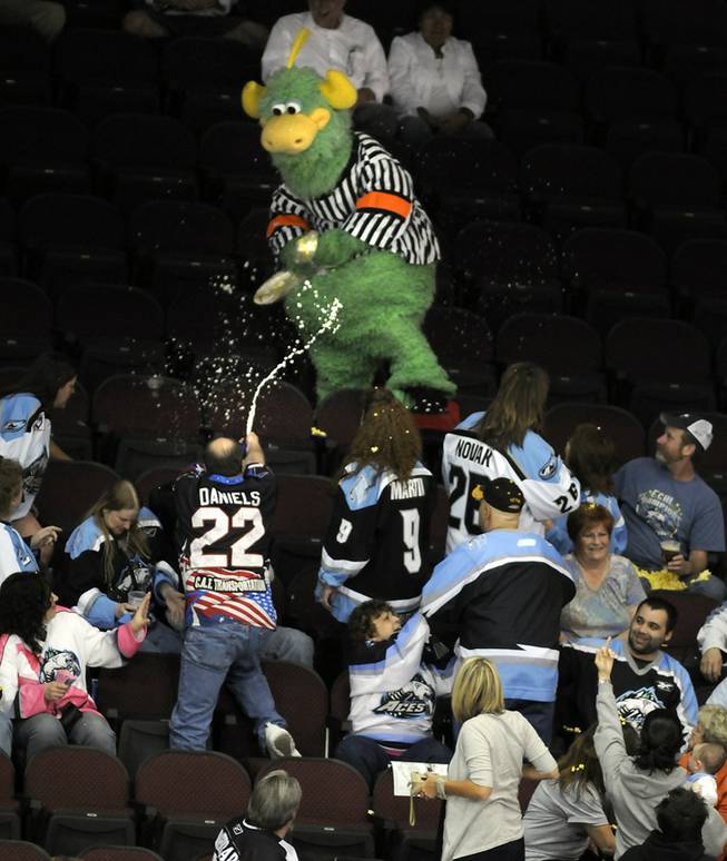 The Las Vegas Wranglers mascot, the Duke, runs from the beer-spraying, middle-finger waving wrath of angry Alaska Aces fans after he threw a bag of popcorn on them Tuesday night at the Orleans Arena.