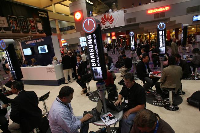 Convention attendees sit at the Samsung Mobile Charging Station on Thursday, the second day of CTIA Wireless 2009 at the Las Vegas Convention Center.