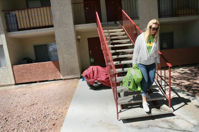 Jaqueline Peterson, director of strategic communications for Harrahs Entertainment, handed out energy-efficient light bulbs at The Pines apartment complex Saturday as part of a community service project put on by the Harrahs Entertainment Reaching Out program.