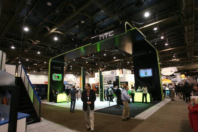 Convention attendees walk past the HTC booth on Thursday, the second day of CTIA Wireless 2009 at the Las Vegas Convention Center.